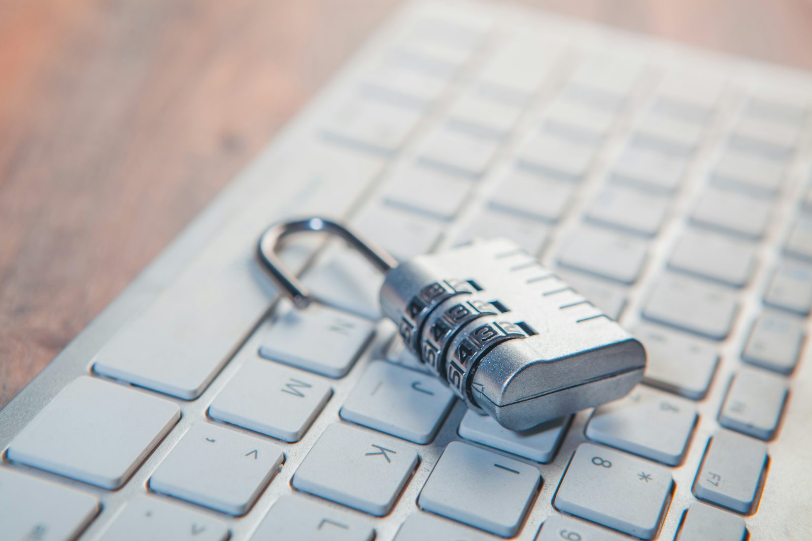 Combination lock resting on a computer keyboard representing software security and data protection