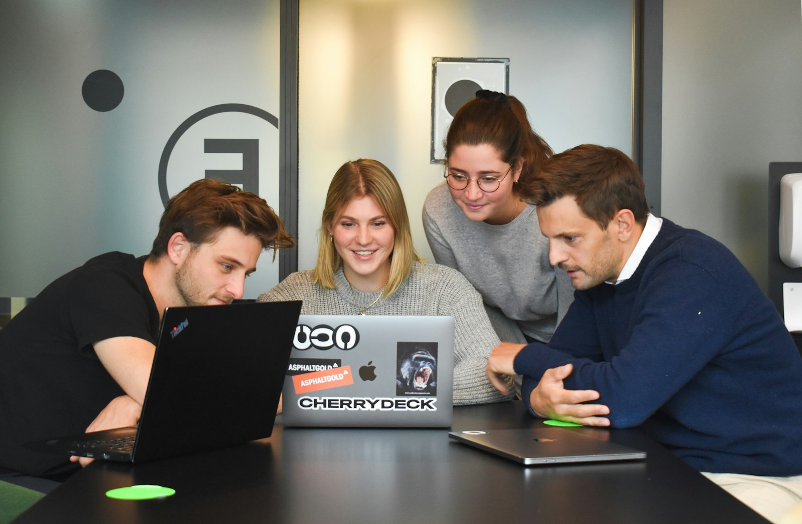Software development team collaborating around a laptop in an office
