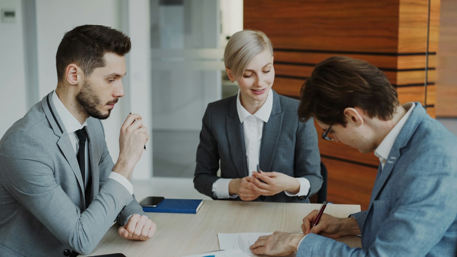 Business team reviewing and signing a software vendor contract at a table