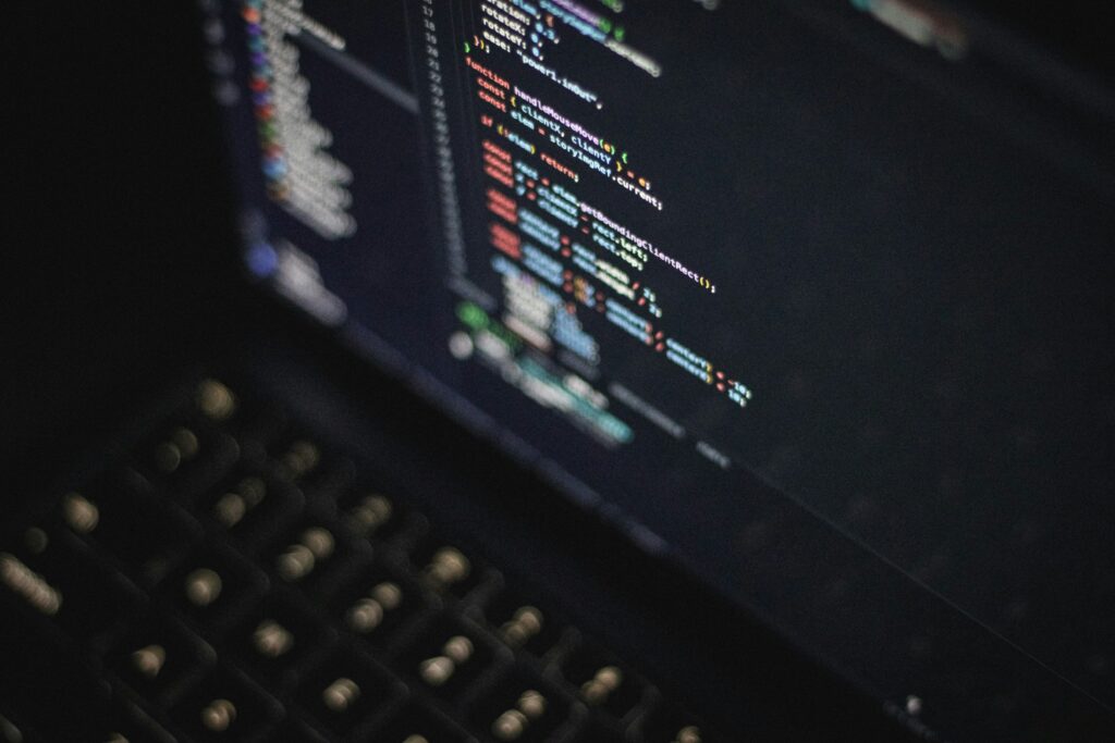 Colorful lines of programming code on a laptop screen in a dark software development workspace