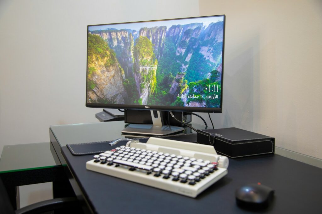 A laptop, external monitor and all-in-one printer arranged on a tidy modern office desk