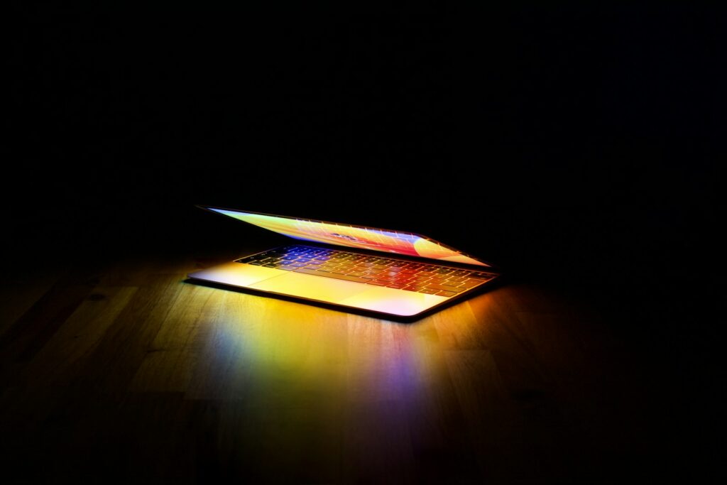 A laptop glowing in a dark room, illustrating an AI model running locally on personal hardware rather than in the cloud.